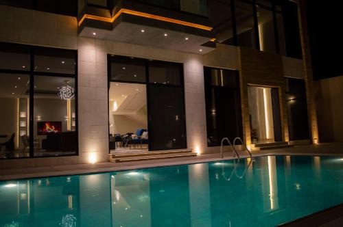una piscina frente a un edificio por la noche en Luxurious villa, en Riad