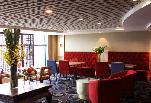 a waiting room with red chairs and tables at Wyndham Garden Suzhou in Suzhou
