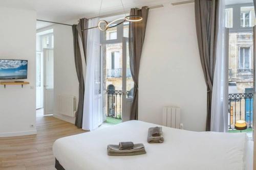 波爾多的住宿－Charmant logement - Gambetta - Cœur Historique Bordeaux，卧室设有白色的床和大窗户