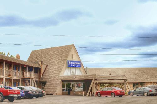 a building with cars parked in a parking lot at Thunderbird Lodge in Mitchell
