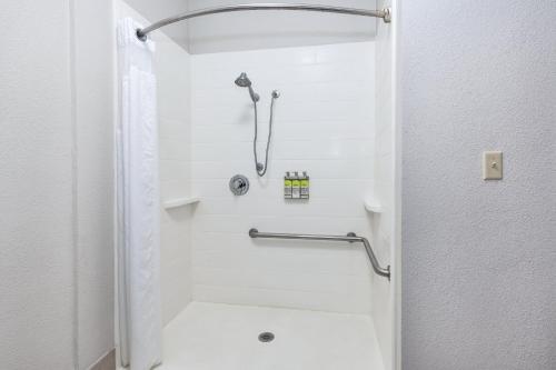 a white bathroom with a shower and a toilet at Holiday Inn Express and Suites Three Rivers, an IHG Hotel in Three Rivers