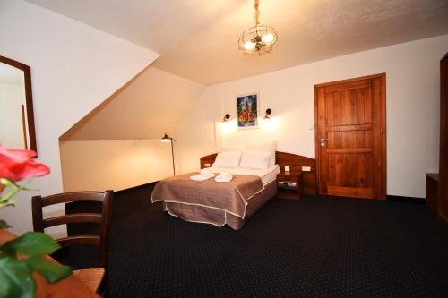 um quarto de hotel com uma cama e uma porta de madeira em Kraina Jezior em Ostróda
