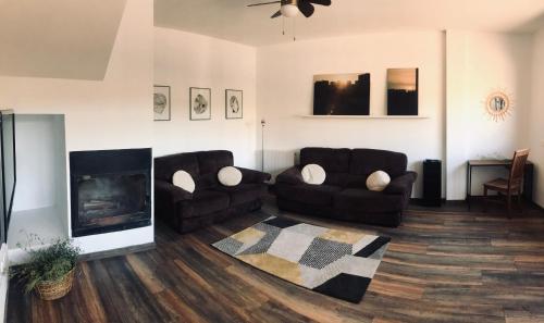 sala de estar con 2 sofás y chimenea en Chez Chloe, en Murillo de Gállego