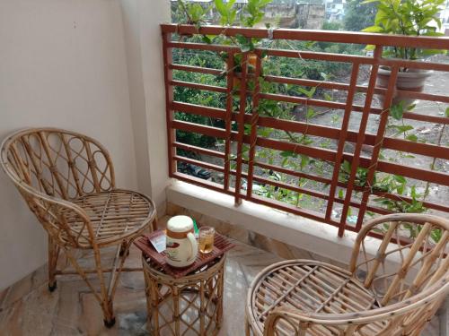 a balcony with two chairs and a table and a window at Rudram Hotel Yoga & Ayurveda Retreat in Rishīkesh