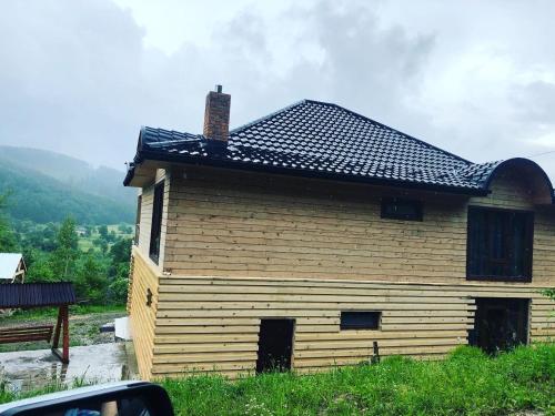 a large wooden building with a black roof at RIVIERA in Lekechi
