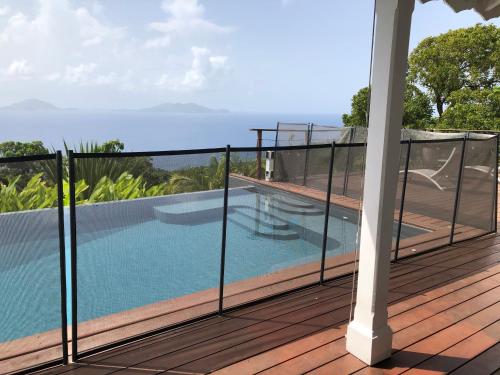 a balcony with a view of a swimming pool at Villa Cajou chambres d'hôtes chez l'habitant et Zanzibar cottage in Trois-Rivières