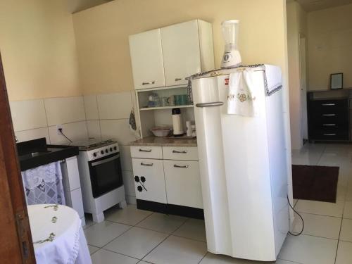 een keuken met een witte koelkast en een fornuis bij Apto Praia de Setiba 2 in Guarapari