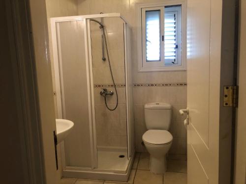 a bathroom with a shower and a toilet and a sink at Limnaria Villas - comfy 2 bed, 2 bath ground floor apartment in Paphos
