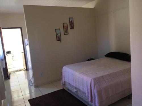 1 dormitorio con 1 cama y cuadros en la pared en Apto Praia de Setiba 2, en Guarapari
