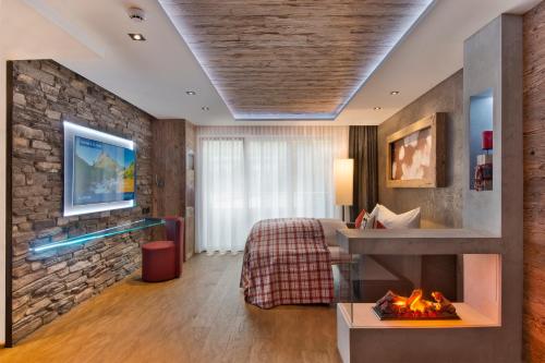 ein Hotelzimmer mit einem Bett und einem Kamin in der Unterkunft PETE - Alpine Boutique Hotel in Sankt Anton am Arlberg