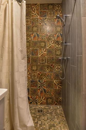 a bathroom with a shower with a tiled wall at KUBU Loft in Klaipėda