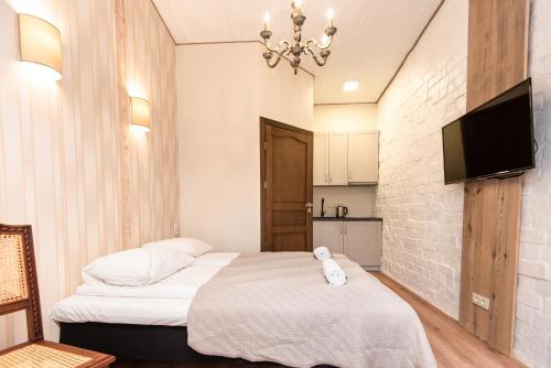 a bedroom with a bed and a flat screen tv at KUBU Loft in Klaipėda