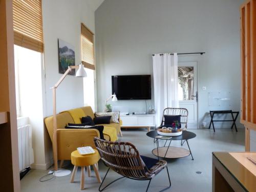 a living room with a yellow couch and chairs at La Maison de Madame Baudy in Giverny