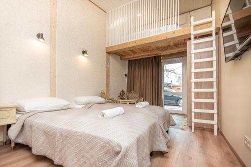 2 łóżka w pokoju z łóżkiem na podwyższeniu w obiekcie KUBU Loft w Kłajpedzie