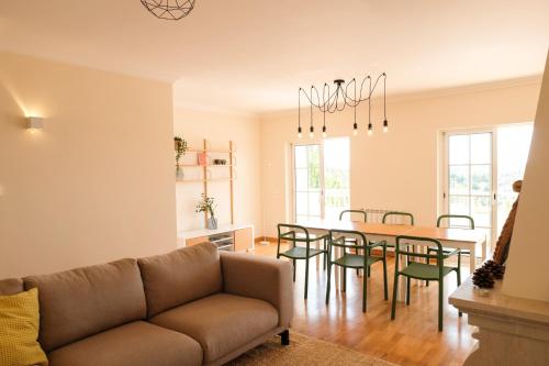 - un salon avec un canapé, une table et des chaises dans l'établissement Casa Clementine, à Salema