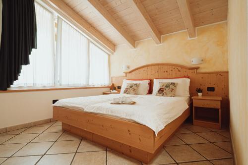 1 dormitorio con 1 cama grande y cabecero de madera en Agritur Val d'Adige, en Trento