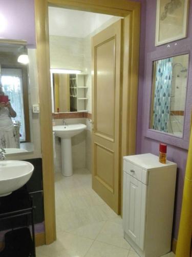 a bathroom with a sink and a toilet and a door at Porta di Roma locazione turistica in Rome