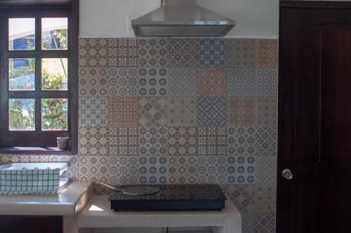 a kitchen with a tiled wall with a window at Costera 171 · Guest House in Bacalar