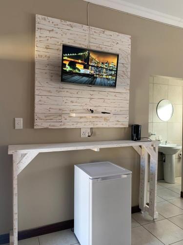 a room with a table with a television on a wall at Bread & Barrel Eureka Kimberley in Kimberley