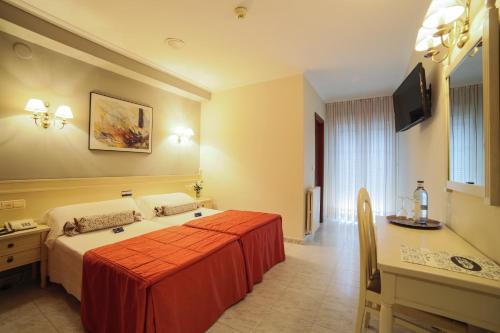 a hotel room with a bed and a desk at San Marcos Salnés in Cambados