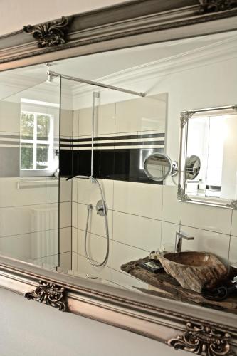 a bathroom mirror with a sink and a shower at VILLA ADELEes BOUTIQUE HOTEL in Alsfeld
