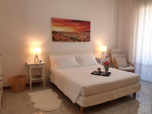 1 dormitorio con 1 cama blanca grande y 1 silla en Godi Fiorenza Suite, en Florencia