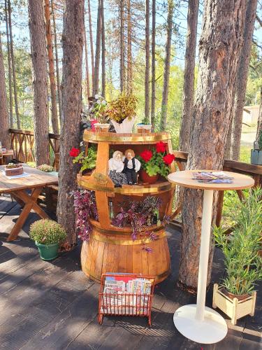 a patio with a table and a barrel with flowers at Apartment White Bear in Zlatibor