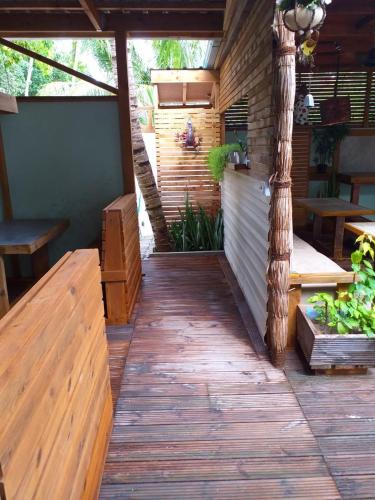 an outdoor patio with wooden benches and a table at Dive Villa Thoddoo in Thoddoo