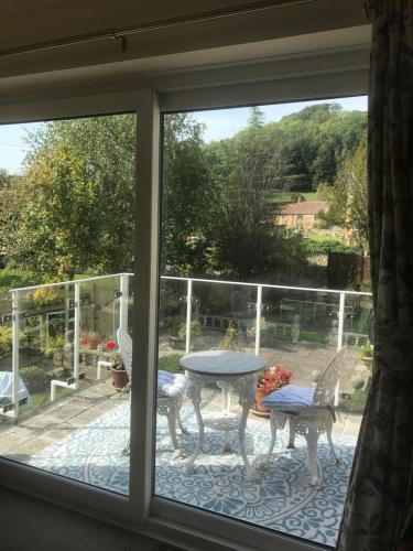 a window view of a patio with a table and chairs at Carents House in Montacute