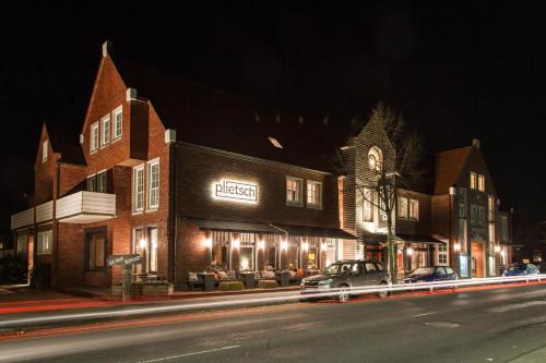 a car parked in front of a building at night at Krögers Hotel in Esens