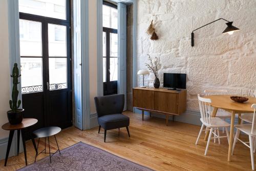 uma sala de estar com uma mesa, uma cadeira e uma secretária em Oporto City View - Trindade em Porto
