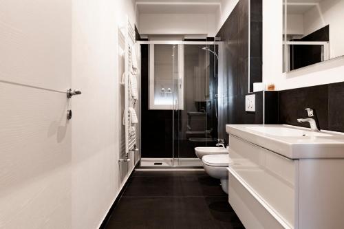 Un baño blanco con lavabo e inodoro. en Roma Ariston 7, en Bolzano