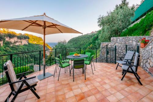 a patio with a table and chairs and an umbrella at Villa San Lorenzo in Scala