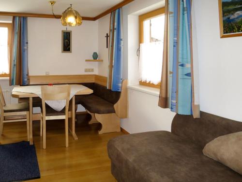 uma sala de estar com uma mesa e um sofá em Holiday Home Wallner - FUC110 by Interhome em Fusch an der Glocknerstraße