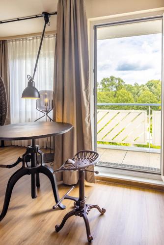 a table and a chair in front of a window at Seminaris Hotel Bad Boll in Bad Boll