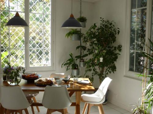 ein Esszimmer mit einem Holztisch und weißen Stühlen in der Unterkunft Les petits poissons in Avignon