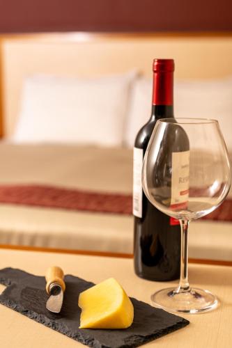 a bottle of wine and a glass on a table at Rede Andrade CWB in Curitiba