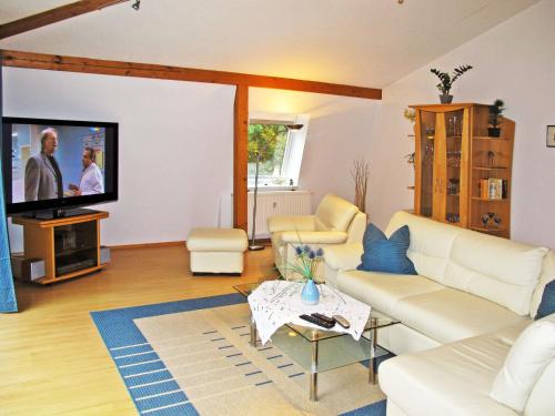 a living room with white furniture and a flat screen tv at Apartment Haus Berlin-5 by Interhome in Loddin