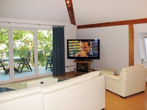 a living room with a couch and a flat screen tv at Apartment Haus Berlin-5 by Interhome in Loddin