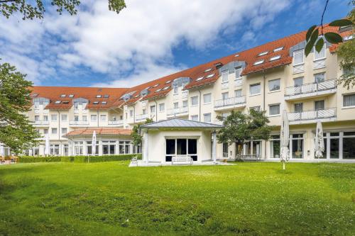 a large building with a green lawn in front of it at Seminaris Hotel Bad Boll in Bad Boll