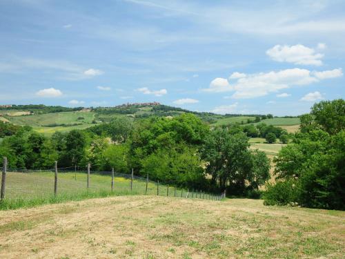 ein Zaun mitten auf einem Feld mit Bäumen in der Unterkunft Holiday Home Podere S Giovanni by Interhome in Casole dʼElsa