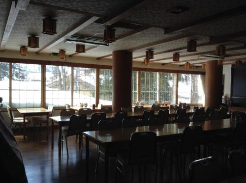 a conference room with tables and chairs and windows at Resort Inn Chitose in Nozawa Onsen