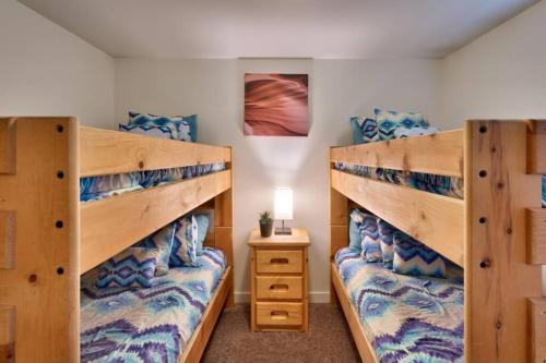 a bedroom with two bunk beds and a night stand at 5L Top Floor Redcliff Condo in Moab
