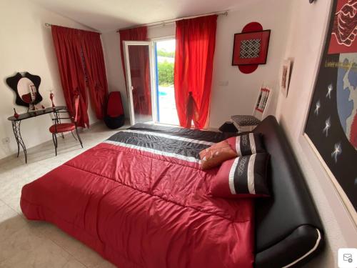 een slaapkamer met een groot bed met rode lakens bij Villa CHELSEA in Vilamoura