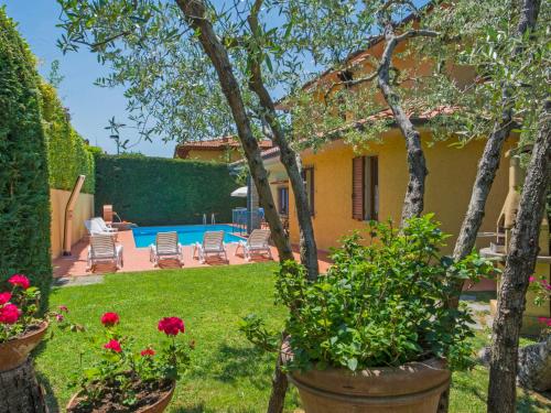una casa con un cortile fiorito e una piscina di Villa Villa Giada by Interhome a Villa Bensi