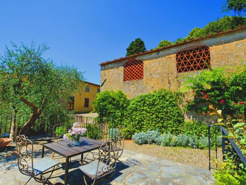 a patio with a table and chairs in a garden at Holiday Home Casa delle Fiabe by Interhome in San Casciano in Val di Pesa