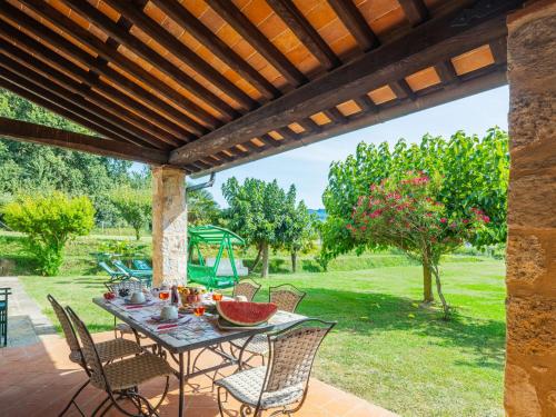 patio ze stołem i krzesłami pod drewnianą pergolą w obiekcie Holiday Home I Pioppi - CMA108 by Interhome w mieście Camaiore