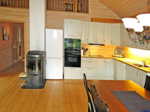 a kitchen with a table and a refrigerator and a stove at Holiday Home Peer Gynt by Interhome in Sogndal