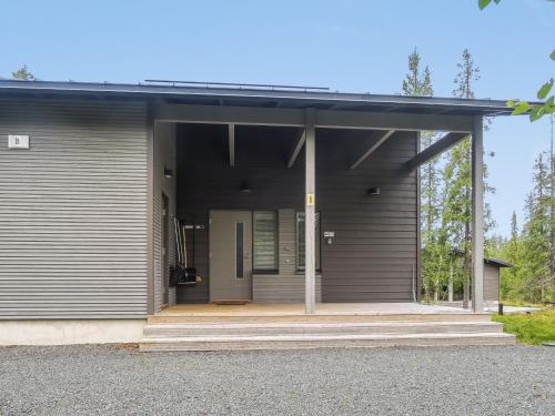 a gray house with a large door and a porch at Holiday Home Villa vuosseli b 1 by Interhome in Ruka