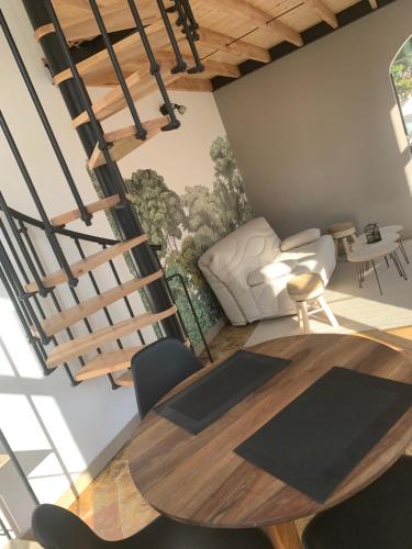 une chambre avec une table et des chaises et un escalier en colimaçon dans l'établissement La Chapelle, à Mamers